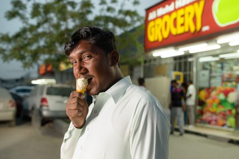 Homme qui mange une glace devant un magasin de dubai Al Quoz